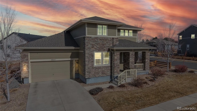 view of front of house featuring driveway, stone siding, an attached garage, and a shingled roof