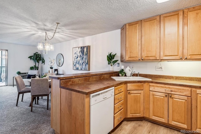 kitchen with dishwasher, sink, hanging light fixtures, light wood-type flooring, and a notable chandelier