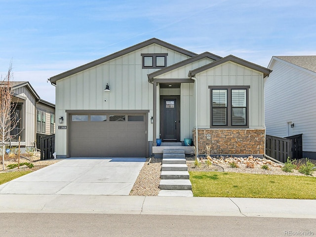 11464 Stonewash St, Littleton, CO 80125 - view of front of house featuring board and batten siding, a garage, driveway, and stone siding