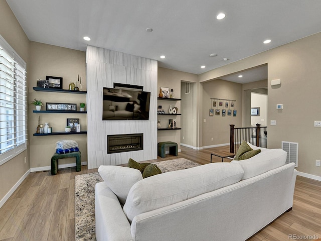 11464 Stonewash St, Littleton, CO 80125 - living room featuring a large fireplace, baseboards, recessed lighting, and light wood finished floors