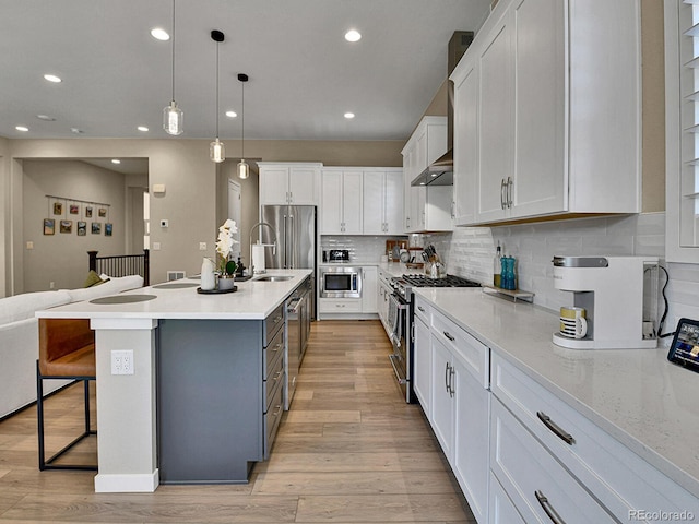 11464 Stonewash St, Littleton, CO 80125 - kitchen with stainless steel appliances, white cabinets, a breakfast bar area, light wood-style flooring, and recessed lighting