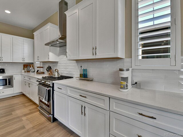 11464 Stonewash St, Littleton, CO 80125 - kitchen with appliances with stainless steel finishes, wall chimney range hood, white cabinets, backsplash, and recessed lighting