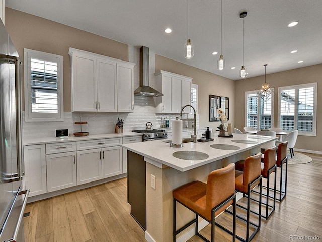 11464 Stonewash St, Littleton, CO 80125 - kitchen featuring wall chimney range hood, freestanding refrigerator, white cabinets, backsplash, and recessed lighting
