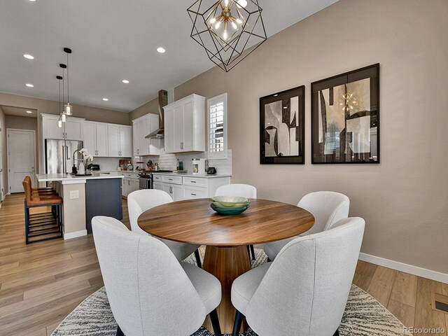 11464 Stonewash St, Littleton, CO 80125 - dining area with a chandelier, baseboards, light wood-type flooring, and recessed lighting