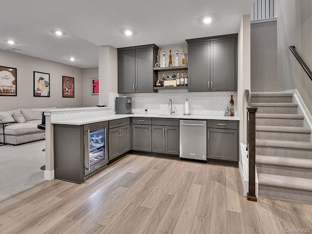 11464 Stonewash St, Littleton, CO 80125 - kitchen with stainless steel dishwasher, a sink, wine cooler, light wood-style flooring, and a peninsula