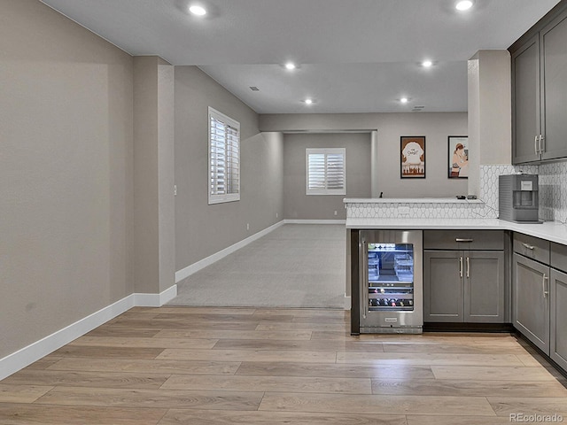 11464 Stonewash St, Littleton, CO 80125 - kitchen with wine cooler, gray cabinets, light wood finished floors, decorative backsplash, and recessed lighting