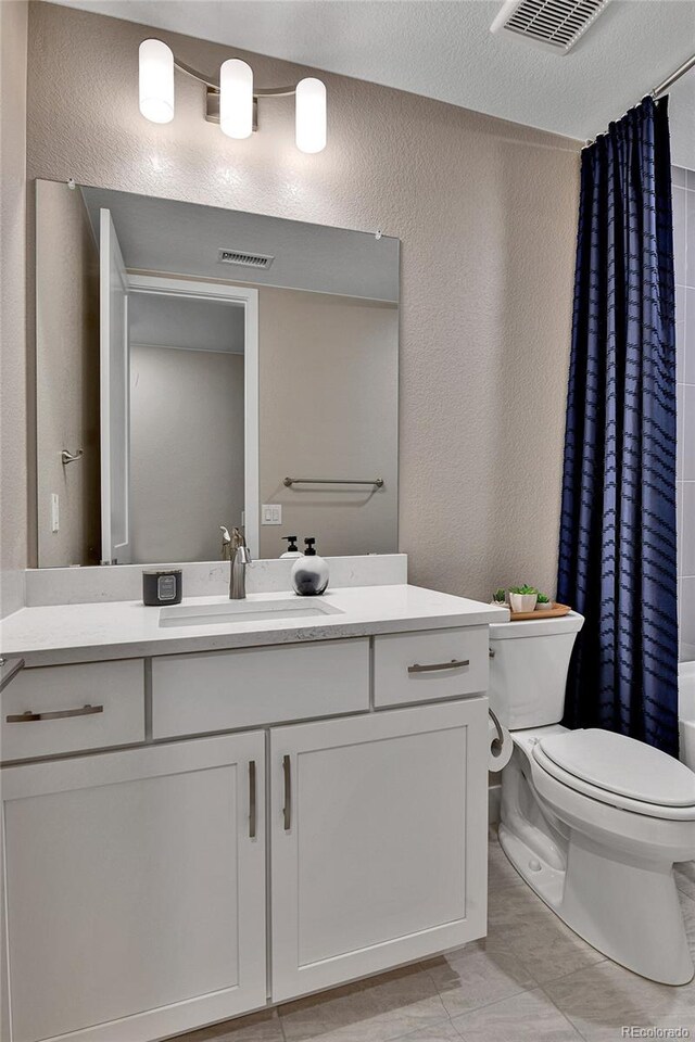 11464 Stonewash St, Littleton, CO 80125 - full bathroom with toilet, vanity, a textured wall, and tile patterned floors