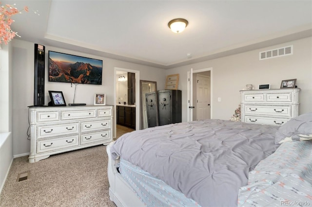 bedroom with light colored carpet and ensuite bath