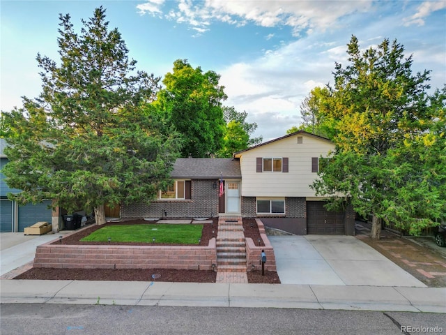 9123 W Arbor Ave, Littleton, CO 80123 - tri-level home with a garage, brick siding, and driveway