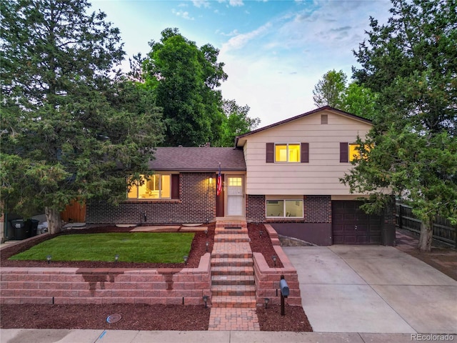 9123 W Arbor Ave, Littleton, CO 80123 - tri-level home with an attached garage, brick siding, driveway, and roof with shingles
