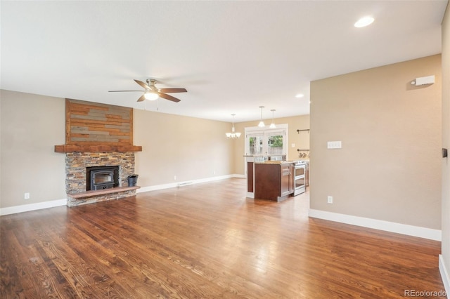4293 Graham Ct, Boulder, CO 80305 - unfurnished living room featuring a ceiling fan, wood finished floors, a stone fireplace, baseboards, and a chandelier
