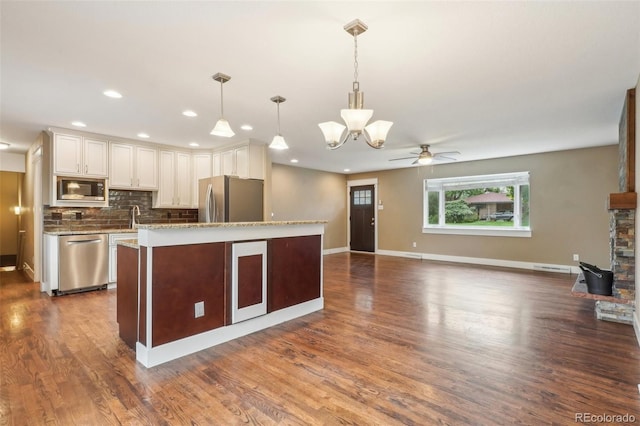 4293 Graham Ct, Boulder, CO 80305 - kitchen featuring stainless steel appliances, a chandelier, decorative backsplash, dark wood-style flooring, and white cabinets