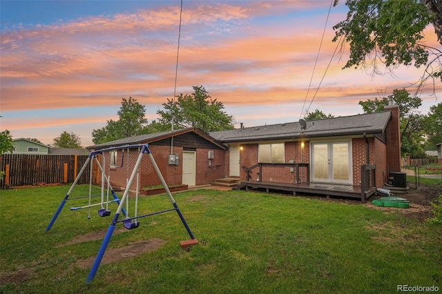 4293 Graham Ct, Boulder, CO 80305 - back of property at dusk featuring a playground, a chimney, brick siding, central AC, and a deck