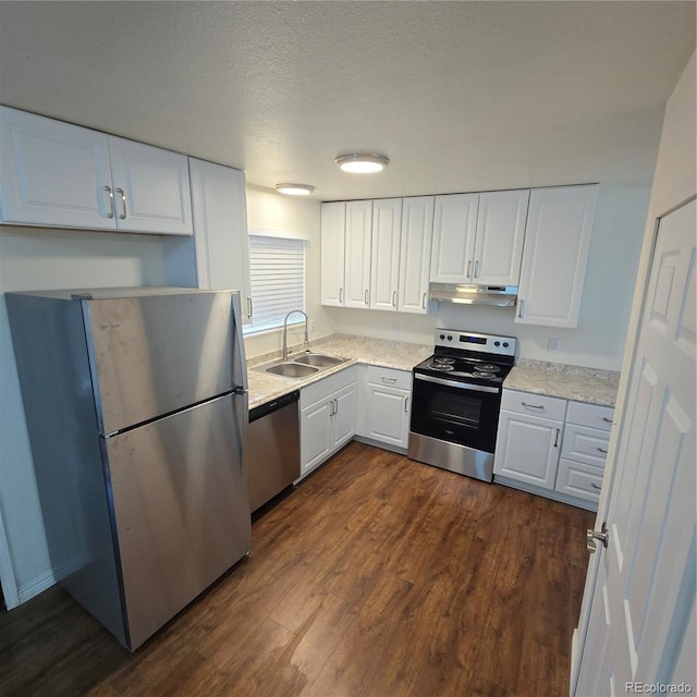 1512 12th Ave Unit 5, Greeley, CO 80631 - kitchen with stainless steel appliances, a sink, under cabinet range hood, white cabinets, and dark wood finished floors
