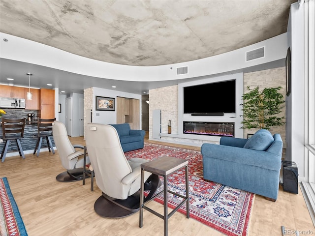 891 14th St Unit 1709, Denver, CO 80202 - living room featuring light wood-style flooring, a glass covered fireplace, and recessed lighting
