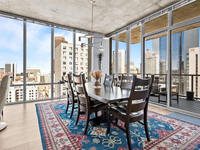891 14th St Unit 1709, Denver, CO 80202 - dining room featuring a wall of windows, a skyline view, and wood finished floors