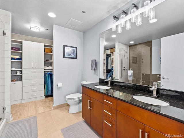 891 14th St Unit 1709, Denver, CO 80202 - bathroom with a walk in closet, double vanity, a shower stall, and tile patterned flooring