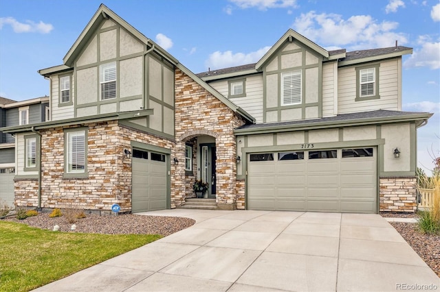 tudor-style house featuring roof with shingles, stucco siding, a garage, stone siding, and driveway