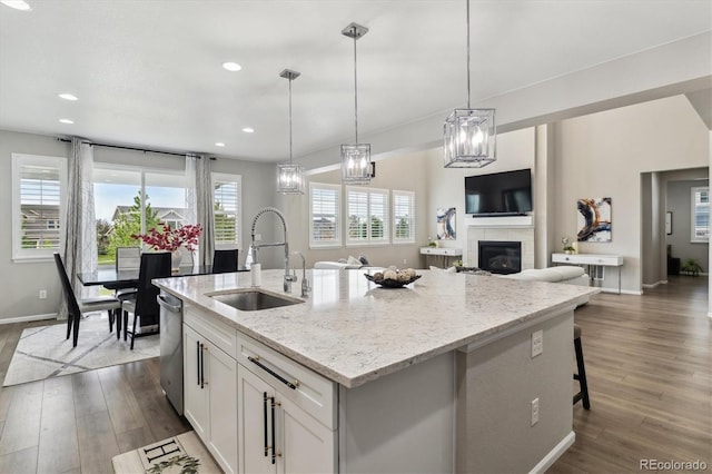 kitchen featuring dark wood finished floors, white cabinets, dishwasher, and a sink