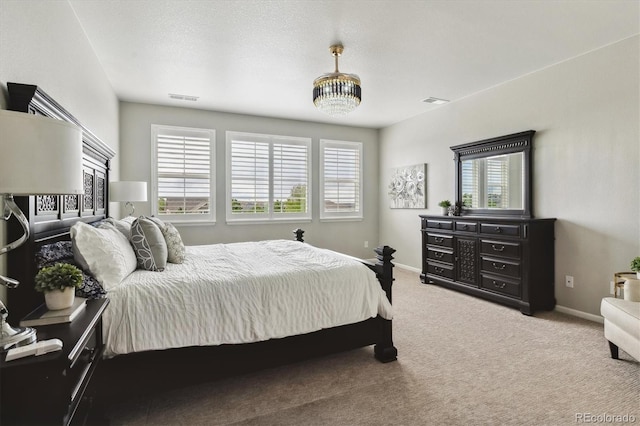 carpeted bedroom featuring multiple windows, baseboards, and visible vents