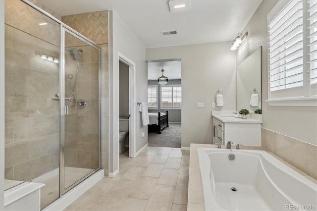 ensuite bathroom featuring vanity, visible vents, a shower stall, a garden tub, and toilet