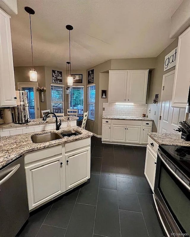 kitchen with hanging light fixtures, stainless steel appliances, backsplash, sink, and white cabinetry