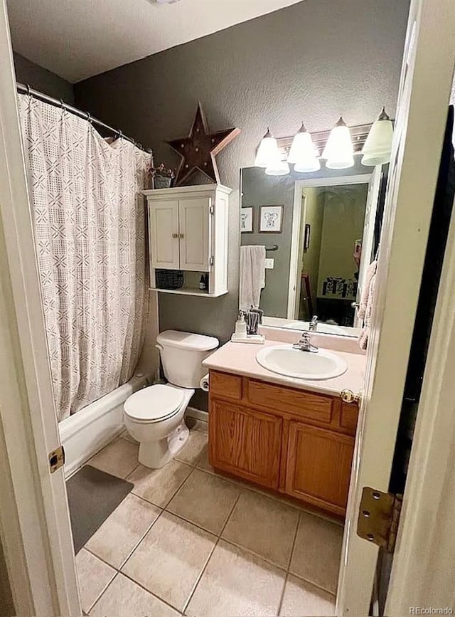 full bathroom with vanity, shower / bathtub combination with curtain, toilet, and tile patterned floors