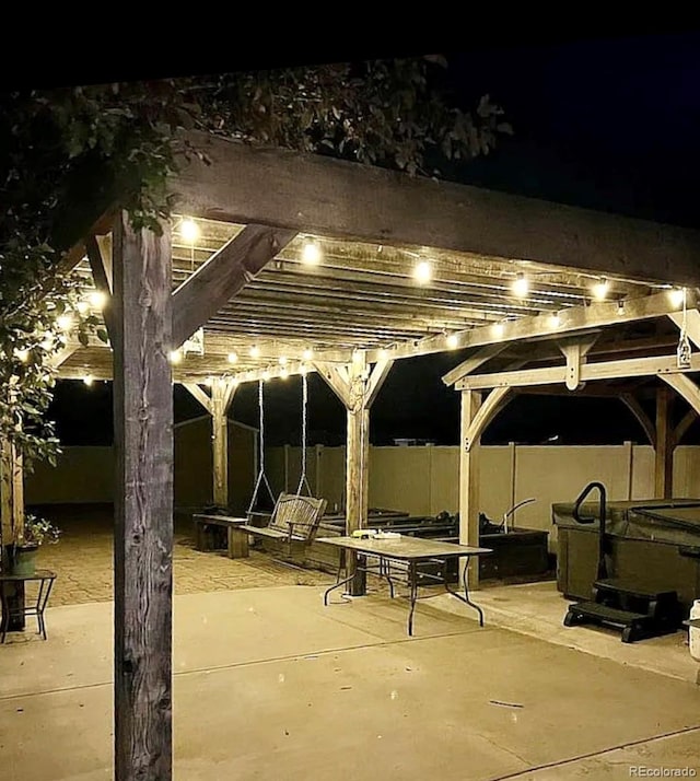 patio at night featuring a pergola