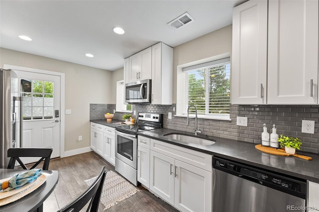 1655 N Yates St, Denver, CO 80204 - kitchen featuring appliances with stainless steel finishes, dark countertops, healthy amount of natural light, and recessed lighting