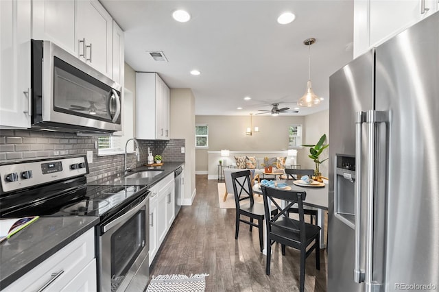 1655 N Yates St, Denver, CO 80204 - kitchen with stainless steel appliances, recessed lighting, backsplash, white cabinetry, and dark wood-type flooring
