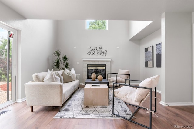 4257 S Andes Way, Aurora, CO 80013 - living room featuring light wood finished floors, healthy amount of natural light, and a tile fireplace