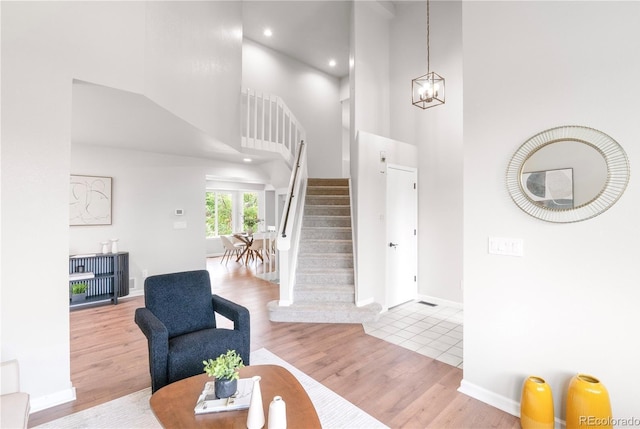 4257 S Andes Way, Aurora, CO 80013 - living room featuring a high ceiling, wood finished floors, stairway, recessed lighting, and a chandelier