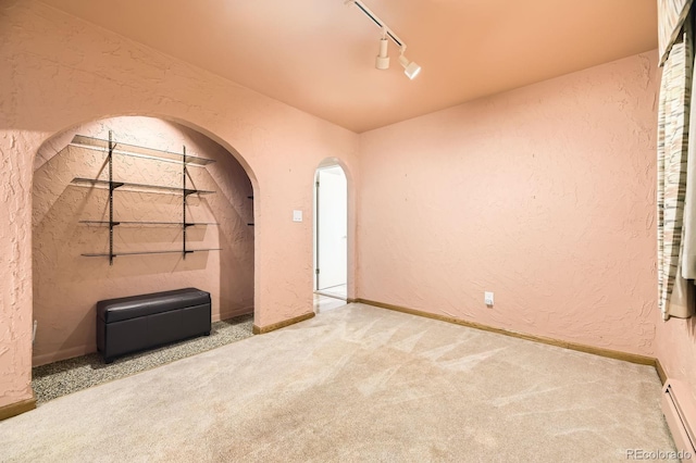 6710 W Nevada Pl, Lakewood, CO 80226 - carpeted spare room with a textured wall, a baseboard heating unit, rail lighting, and arched walkways