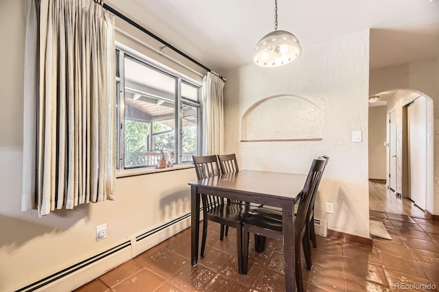 6710 W Nevada Pl, Lakewood, CO 80226 - dining area featuring a baseboard radiator, arched walkways, and a textured wall
