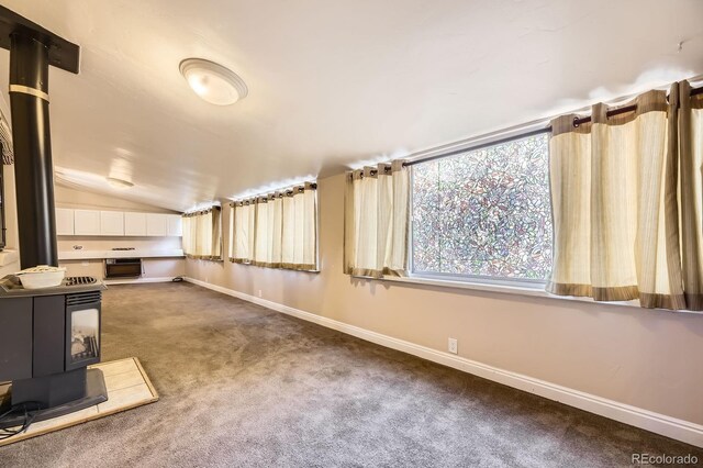 6710 W Nevada Pl, Lakewood, CO 80226 - basement featuring a wood stove and dark colored carpet