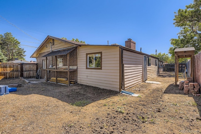 6710 W Nevada Pl, Lakewood, CO 80226 - rear view of house featuring a chimney and a fenced backyard