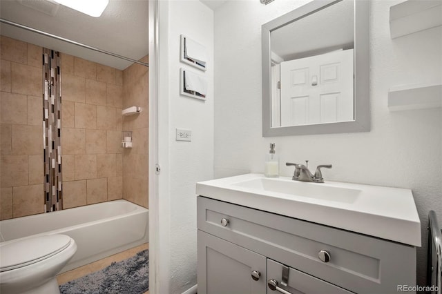 full bathroom featuring vanity, tiled shower / bath combo, and toilet