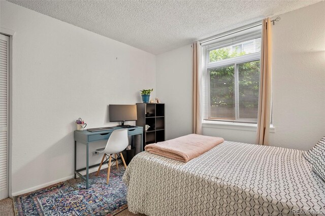 carpeted bedroom featuring a textured ceiling