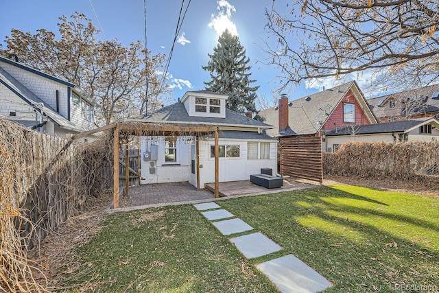 rear view of house featuring an outbuilding, a yard, and a patio