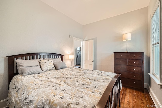 bedroom featuring dark wood-type flooring and multiple windows