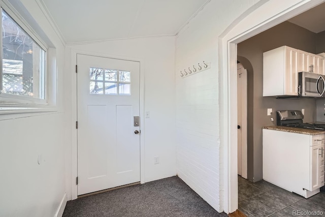 entryway with lofted ceiling and ornamental molding