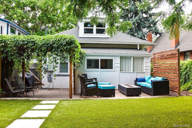 rear view of property featuring a yard, a patio area, and an outdoor living space with a fire pit