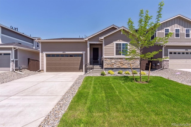 18951 E 96th Pl, Commerce City, CO 80022 - view of front facade featuring an attached garage, a front lawn, driveway, and stone siding