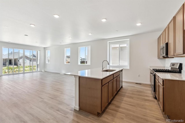 18951 E 96th Pl, Commerce City, CO 80022 - kitchen featuring appliances with stainless steel finishes, light wood-style flooring, an island with sink, light countertops, and recessed lighting
