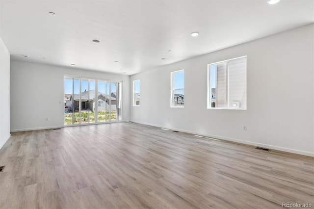18951 E 96th Pl, Commerce City, CO 80022 - unfurnished living room featuring plenty of natural light, light wood finished floors, and recessed lighting