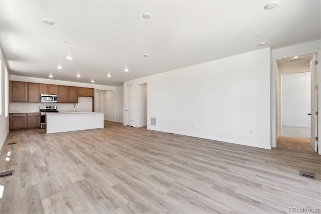 18951 E 96th Pl, Commerce City, CO 80022 - unfurnished living room featuring light wood-style floors and recessed lighting