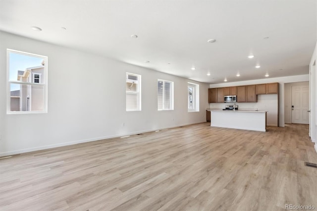 18951 E 96th Pl, Commerce City, CO 80022 - unfurnished living room featuring light wood-type flooring and recessed lighting