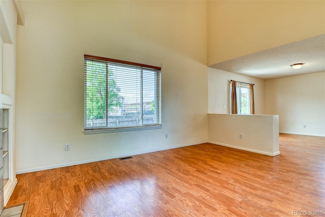 5831 Moon Ridge Dr, Colorado Springs, CO 80922 - empty room with light wood finished floors, a towering ceiling, and baseboards