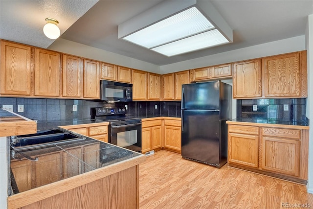 5831 Moon Ridge Dr, Colorado Springs, CO 80922 - kitchen with black appliances, tile counters, backsplash, light wood-style floors, and a sink