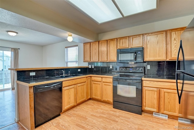 5831 Moon Ridge Dr, Colorado Springs, CO 80922 - kitchen with black appliances, a sink, a peninsula, tasteful backsplash, and tile countertops